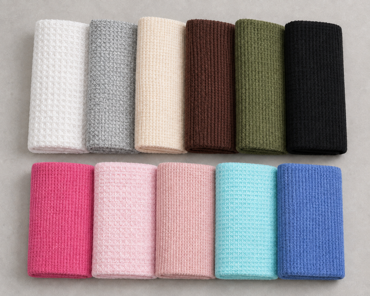 AI-restaged source composition of eleven waffle-knit fabric cuts, preserving their varied knit textures and colors.